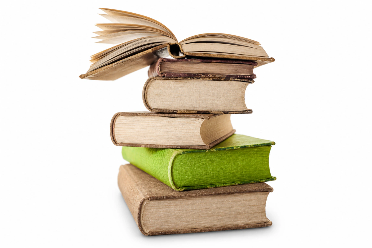 Pila de libros antiguos con un volumen verde y un libro abierto